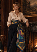 Woman wearing the BEE LOVE No. I Grand Square 135 x 135 100% Italian silk scarf as a cummerbund beside a fireplace